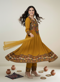 Woman wearing a green kurta with red patterns against a white curtain background