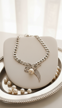 Silver chain necklace with a pendant on a white surface