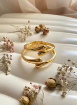 Gold ring on a white surface with dried flowers