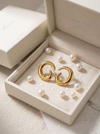 Gold earrings in a jewelry box with pearls