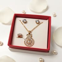 Gold necklace and earrings set in a red box with pearls around