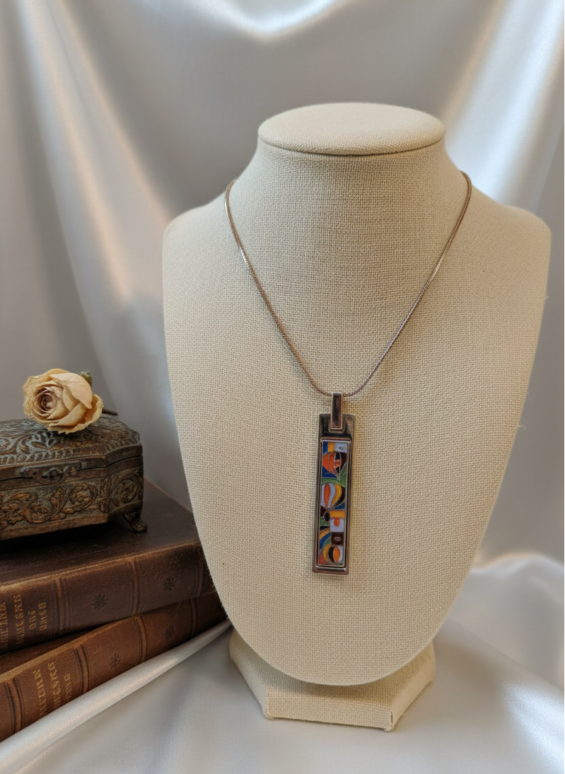 Necklace with a colorful pendant on a mannequin bust against a neutral background