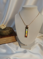 Necklace with a colorful pendant on a mannequin bust against a white background