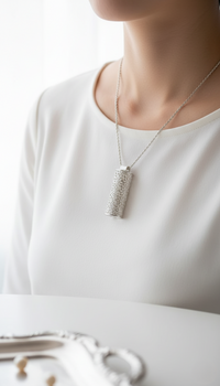 Silver necklace with a textured pendant on a white background