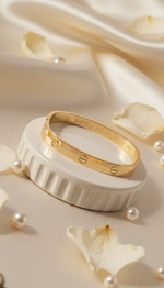 Gold ring on a decorative white base with pearls and petals around
