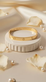 Gold bracelet on a decorative stand with pearls and petals