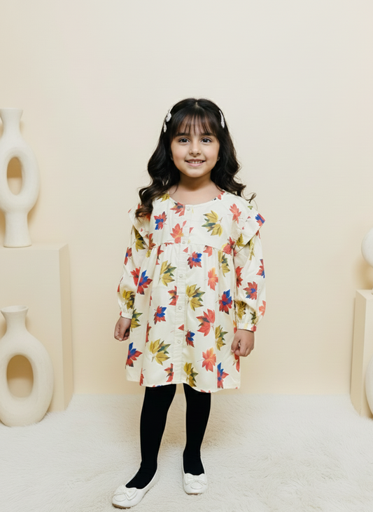 Young girl wearing a floral dress standing against a neutral background