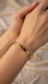 Gold bracelet on a wrist with a soft, neutral background