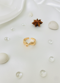 Gold ring on a white surface with pearls and anise stars