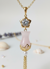 Necklace with pink pendant and gold chain on a light background