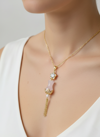 Gold necklace with a pink pendant on a mannequin