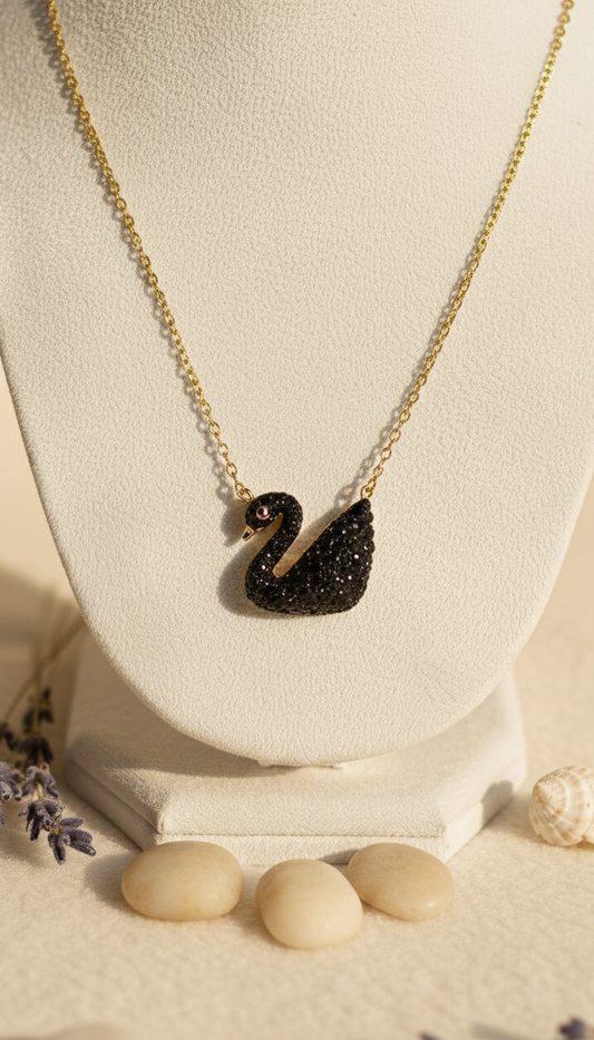 Black swan necklace on a white stand with stones and lavender flowers on a beige background