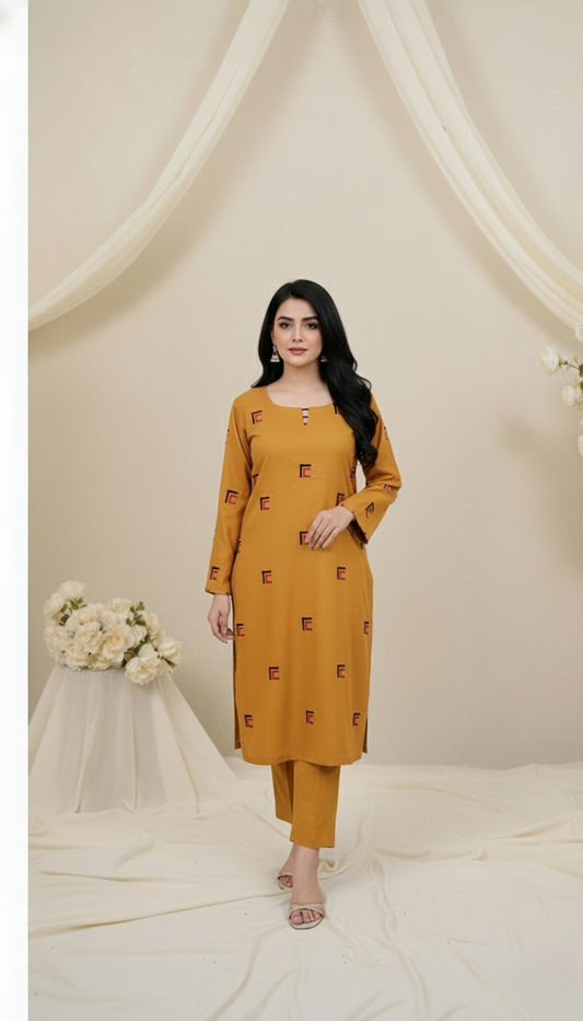 Woman wearing a mustard yellow outfit with floral decorations against a white curtain background