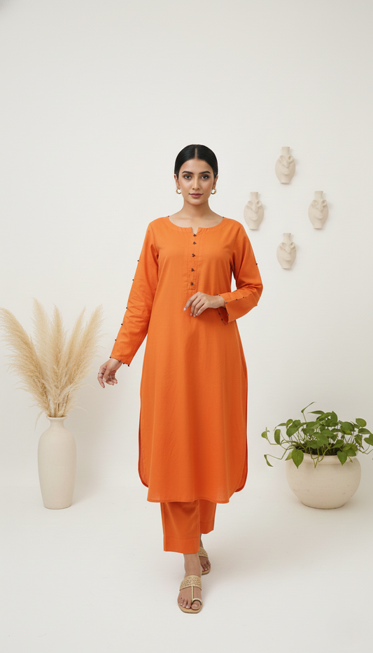 Woman wearing an orange kurta with white pants standing against a white background with decorative elements.