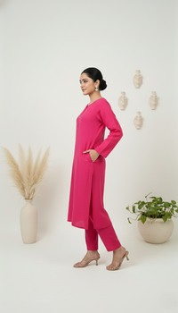 Woman wearing a pink outfit standing against a white background with decorative elements.