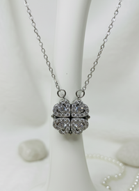 Silver necklace with a heart-shaped pendant on a white background