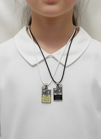 Two necklaces with pendant tags on a white shirt
