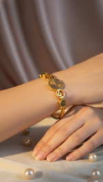Gold bracelet on a wrist with pearls around