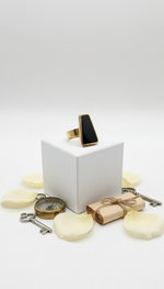 Black ring on a white box with decorative items on a light gray background