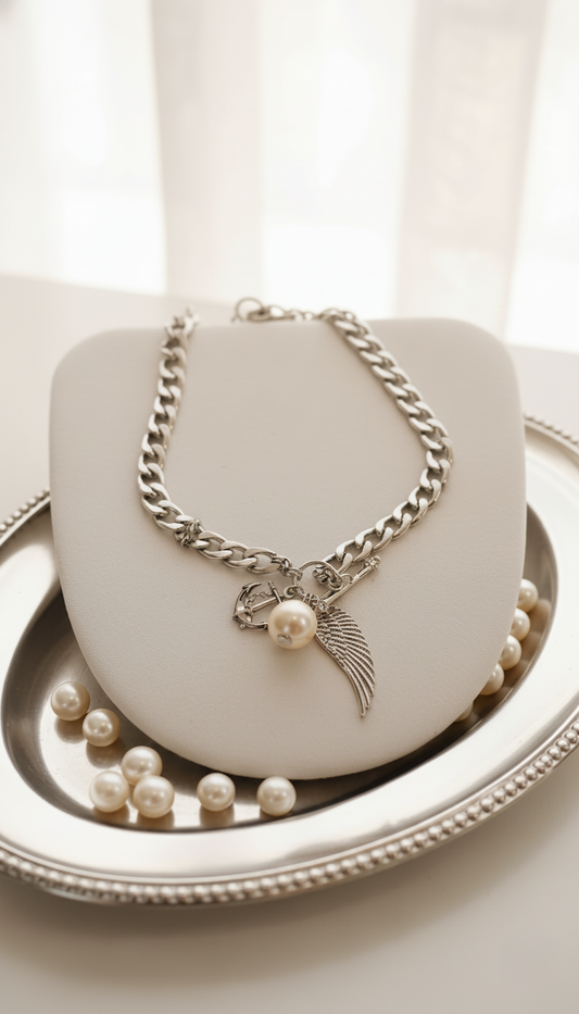 Silver chain necklace with a pendant on a white surface