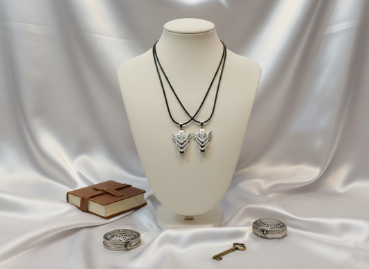 Necklace on a mannequin bust with a book and keys on a white fabric background